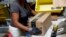 FILE - An Amazon employee applies tape to a package before shipment at an Amazon fulfillment center in Baltimore, Maryland, Aug. 3, 2017. 