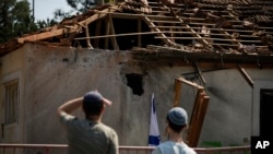 Dos personas observan los daños causados por un proyectil disparado desde Líbano, en un inmueble cerca de Safed, en el norte de Israel, el 25 de septiembre de 2024.