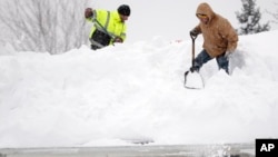 紐約州連日降雪，民眾在屋頂清理厚雪。