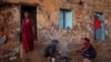 Tigrayans who fled the conflict in Ethiopia's Tigray region, start wood fires to prepare dinner, in front of their temporary shelters at Umm Rakouba refugee camp in Qadarif, eastern Sudan, Dec. 7, 2020. 