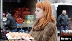 Seorang perempuan membawa telur menuju pasar yang buka seminggu sekali setiap Sabtu, di Stavropol, Rusia selatan, 7 Maret 2015. (Foto: dok). 