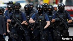 Armed police officers walk outside Borough Market after an attack left 6 people dead and dozens injured in London, Britain, June 4, 2017.