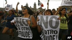 Demonstrators shout slogans as they gather at the Zocalo Plaza in Mexico City, Mexico, July 7, 2012.