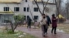 FILE - People walk next to a damaged hospital building as a result of a Russian drone attack in Kyiv, on November 29, 2024, amid the Russian invasion of Ukraine. With snow on the ground, NATO chief Mark Rutte said Russia is using the onset of winter as a weapon in the war.