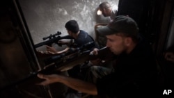 FSA soldiers scan for targets from within a bombed building in Saif Al Dula district in Aleppo, Syria, Monday, Sept. 10, 2012.