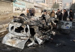 Afghan officials inspect the wreckage of a burnt car at the site of a bomb blast in Kabul, Afghanistan, Jan. 10, 2021.
