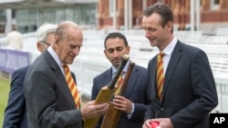 Mantan atlet kriket Inggris John Stephenson (kanan) memperlihatkan raket milik Everton Weekes (salah satu pemain dalam grup kriket West Indian), kepada Pangeran Philip, saat berkunjung ke "Lord's Cricket Ground" untuk membuka Warner Stand yang baru di London, 3 Mei 2017. (Arthur Edward/Pool Photo via AP) 