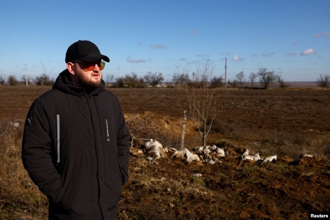 Grain farmer Andrii Povod stands beside his field that has been damaged by shelling and trenches, amid Russia's invasion of Ukraine, in Bilozerka, Kherson region, Ukraine, February 20, 2023. (REUTERS/Lisi Niesner)