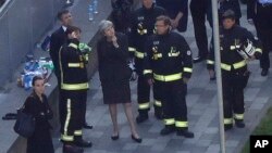 La primera ministra, Theresa May, observa lo que queda de la torre Grenfield en Londres, tras el mortal incendio en el que murieron al menos 17 personas.