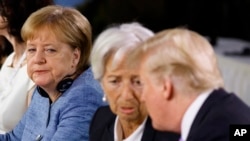 German Chancellor Angela Merkel watches as President Donald Trump talks with IMF Managing Director Christine Lagarde during the Gender Equality Advisory Council breakfast during the G-7 summit, June 9, 2018, in Charlevoix, Canada. 