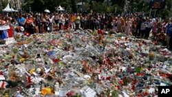 FILE - People gather at the makeshift memorial July 18, 2016, after a minute of silence on the famed Promenade des Anglais in Nice, southern France, to honor the victims of an attack near the area where a truck mowed through revelers.