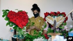 FILE - A merchant prepares a floral arrangement on Mother's Day at the Los Angeles Flower Market in Los Angeles, May 10, 2020.