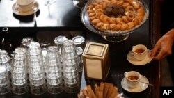 FILE - A customer prepares to drink espresso at a traditional coffee bar in Milan, Italy, Feb. 27, 2017. 