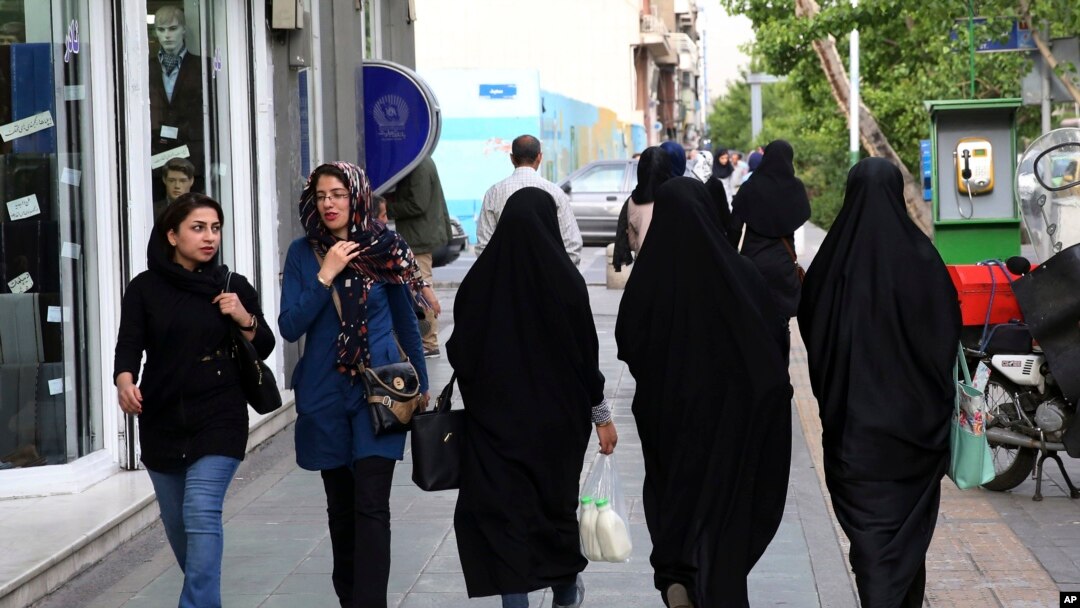FILE - Iranian women make their way along a sidewalk in downtown Tehran, Iran, Apr. 26, 2016. 