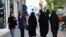 FILE - Iranian women make their way along a sidewalk in downtown Tehran, Iran, Apr. 26, 2016. 