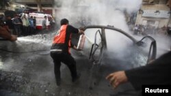 Palestinos extinguen el fuego luego que un misil israelí destruyó el carro en el que viajaba el jefe militar de Hamás, Ahmed al-Jaabari, en la ciudad de Gaza, este miércoles 14 de noviembre de 2012.