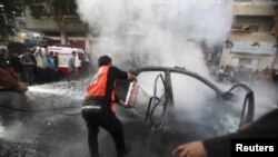 Filistinliler Hamas komutanının yanan aracını söndürmeye çalışırken