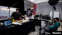 A chef wearing a face mask conducts a cooking lesson through a live-streaming session inside a restaurant at a office as the country is hit by an outbreak of the novel coronavirus that can cause COVID-19 disease, in Shanghai, China March 9, 2020. (REUTERS/Aly Song)