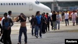 Des migrants clandestins venus du Guatemala, déportés de Phoenix, en Arizona aux États-Unis, arrivent à une base de l'armée de l'air à Guatemala le 22 juillet 2014.