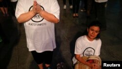 Women pray during a special event for the passengers of the missing Malaysia Airlines MH370 in central Kuala Lumpur March 18, 2014.