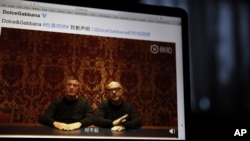 Founders of Dolce&Gabbana Domenico Dolce, left, and Stefano Gabbana apologize in a video on Chinese social media, saying "sorry" in Mandarin seen on a computer screen in Beijing, China, Friday, Nov. 23, 2018.