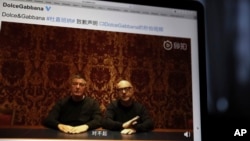 Founders of Dolce&Gabbana Domenico Dolce, left, and Stefano Gabbana apologize in a video on Chinese social media, saying "sorry" in Mandarin seen on a computer screen in Beijing, China, Friday, Nov. 23, 2018.
