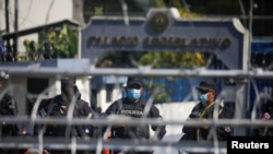 Policías salvadoreños observan a activistas durante una protesta contra el presidente de El Salvador, Nayib Bukele, en el Congreso Nacional en San Salvador, El Salvador, el 9 de febrero de 2021.