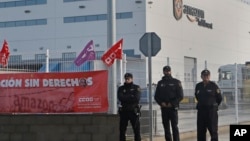 Police guard the entrance of the main Amazon Logistics Center where goods are stored for distribution, on the outskirts of Madrid, Spain, Friday Nov. 22, 2018.