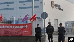 Police guard the entrance of the main Amazon Logistics Center where goods are stored for distribution, on the outskirts of Madrid, Spain, Friday Nov. 22, 2018.