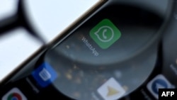 WhatsApp messenger logo is pictured on a phone screen in Moscow on August 26, 2021. - Russia has fined Facebook, Twitter and WhatsApp for failing to store the data of Russian users on local servers, the country's internet watchdog said on August 26, as au