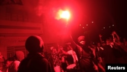 FILE - A man holds a flair during an anti-government protest in Fort-De-France, Martinique, Nov. 28, 2021.