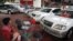A potential customer breastfeeds her baby at a saloon for newly imported cars in central Rangoon, September 23, 2012. 