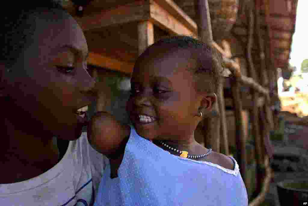 Memuna Mansaray, 3, whose right arm was destroyed by terrorist rebels, plays with her brother Ibrahim, 9, boxing playfully at his face, September 1,1999. (AP)