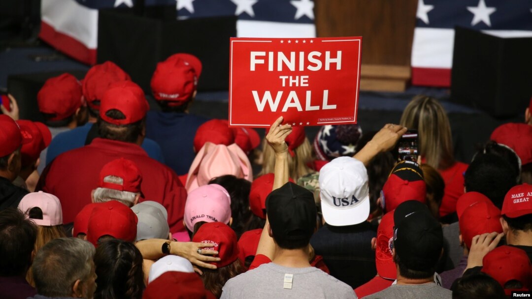 A supporter holds a placard as U.S. President Donald Trump speaks during a rally at El Paso County Coliseum in El Paso, Texas, Feb. 11, 2019. 
