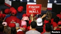 A supporter holds a placard as U.S. President Donald Trump speaks during a rally at El Paso County Coliseum in El Paso, Texas, Feb. 11, 2019. 