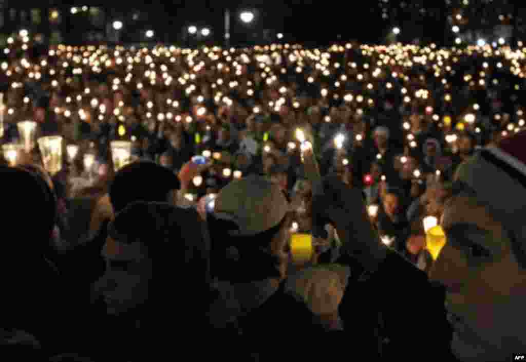 People hold candles during a candlelight vigil in front of the Old Main building on the Penn State Campus Friday, Nov. 11, 2011 in State College, Pa. The vigil is being held in support of the alleged victims of a child sex abuse scandal involving a former