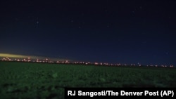 This Jan. 2, 2020, photo shows red lights from wind turbines in the distance in the area of Genoa and Hugo, Colorado, where sightings of unidentified large drones in the air have been reported.