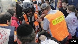 En las cercanías de la estación de autobuses de Jerusalén, rescatistas y paramédicos trasladan a uno de los heridos.