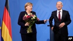 New elected German Chancellor Olaf Scholz, right, has given flowers to former Chancellor Angela Merkel during a handover ceremony in the chancellery in Berlin, Wednesday, Dec. 8, 2021. (Photo/Markus Schreiber)