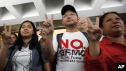 Eman Villanueva (C), vice chairperson of the Filipino Migrant Workers Union, along with other representatives, shows a victory sign after a court ruling in favor of foreign domestic workers seeking permanent residency, Hong Kong September 30, 2011.