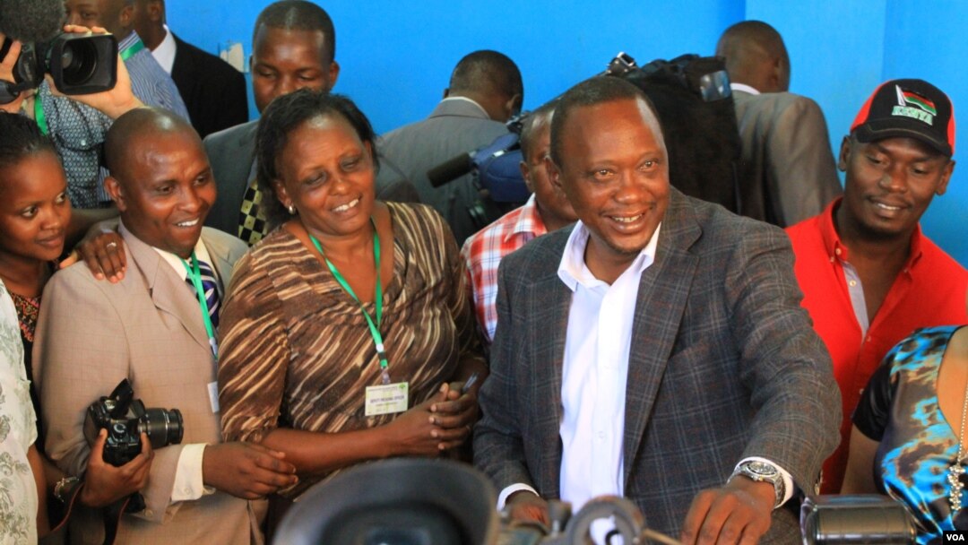 Uhuru Kenyatta oo codkiisa dhiibanaya dad taageersanna ay ku wareegsan yihiin.
