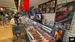 资料照：2023年8月24日，星期四，北京，居民在一家日本超市购买寿司和生鱼片。(美联社）