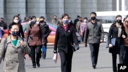Para pejalan kaki mengenakan mengenakan masker untuk pelindung diri dalam menghadapi wabah virus corona di Pyongyang, Korea Utara, 1 April 2020. 