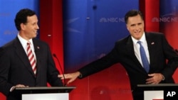 Republican presidential candidates former Massachusetts Gov. Mitt Romney, right, reaches out to former Pennsylvania Sen. Rick Santorum during a Republican presidential debate Monday Jan. 23, 2012, at the University of South Florida in Tampa, Fla.