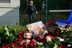 Foto pendiri kelompok tentara bayaran Yevgeny Prigozhin di tempat peringatan di gedung bekas PMC Wagner Center di St. Petersburg, Rusia, Jumat, 25 Agustus 2023. (Foto: Dmitri Lovetsky/AP Photo)