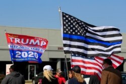 FILE - Voters walk with flags as they arrive to cast their votes early, in Norwood, Ohio, Oct. 6, 2020.