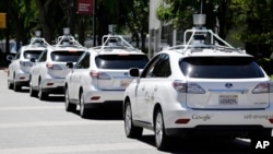 FILE - Google self-driving Lexus cars are seen at a Google event outside the Computer History Museum in Mountain View, California, May 13, 2014.