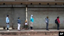 Des Sud-africains font la queue devant une épicerie à Johannesburg, le1er avril 2020. (AP Photo/Jerome Delay)