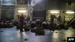 FILE - French military packing their bag aboard the French Navy amphibious assault ship BPC Dixmude moored, in the port of Douala.