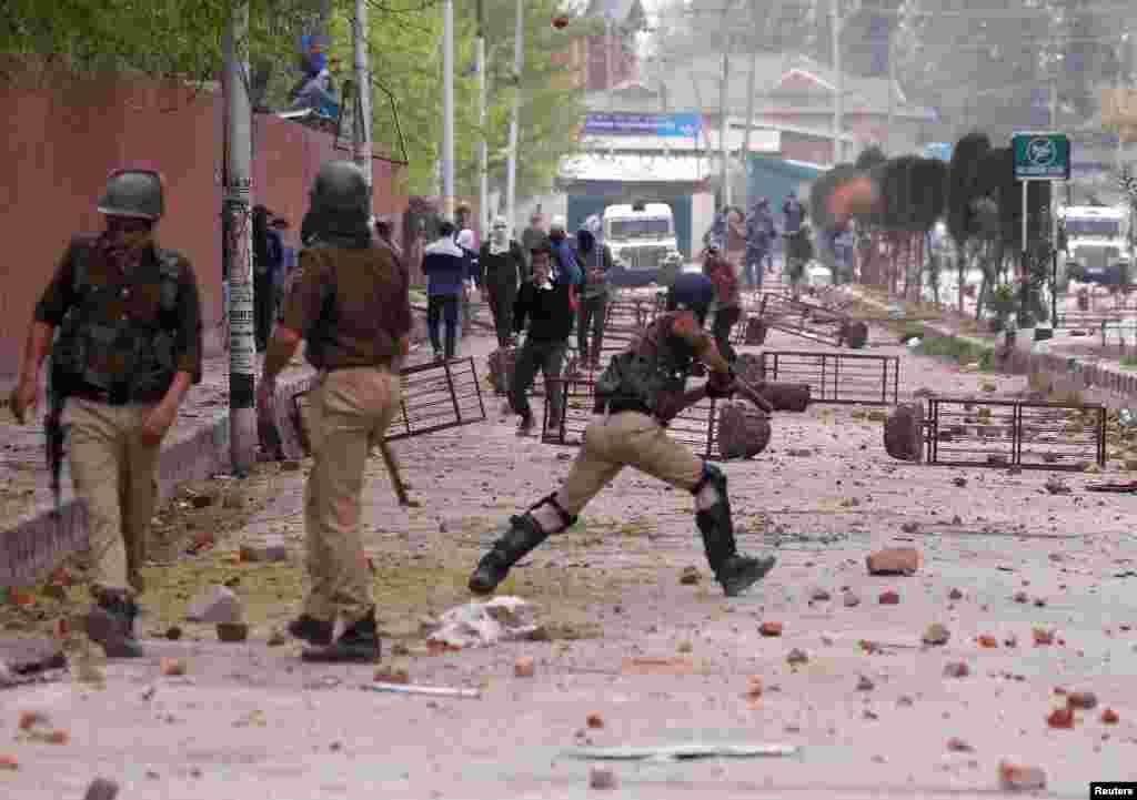 Students hurl stones towards Indian police during a protest against the recent killings in Kashmir, outside a college in Srinagar.